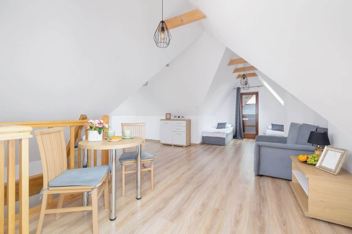 Un apartamento tipo loft moderno con comedor, sofá y kitchenette.