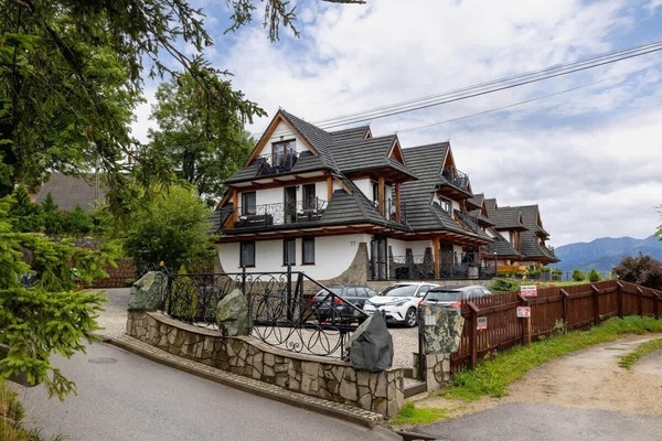 A charming exterior of a highlander-style building, surrounded by greenery and traditional architecture.