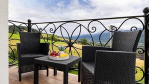 A balcony with wicker furniture and a table set with fruits and a drink. - Cozy Apartment | With Mountain View and Balcony (Koscielisko)