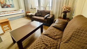 A living room with a sofa, a coffee table, a small table, and a chair. There is a painting on the wall and a window with curtains. - A1018 - Comfort and tranquility by the sea (Cala de Finestrat)