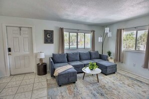 A living room with a sectional sofa, a coffee table, and a lamp.