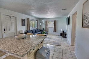 A kitchen with granite countertops, a built-in oven, and a trash can. - Fillmore Unit #8 | 2BR/1BA (Cape Canaveral)