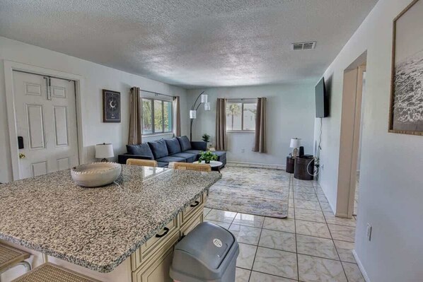 A kitchen with granite countertops, a built-in oven, and a trash can.