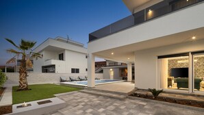 A modern two-story house with a swimming pool, outdoor seating, and a well-maintained garden. - Stunning home in Sukosan with WiFi (Sukosan)