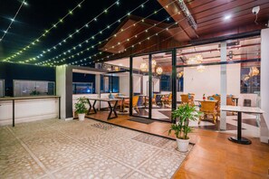 An indoor dining area with tables and chairs, string lights, and potted plants. - The Mohua A Boutique Hotel (Ranchi)