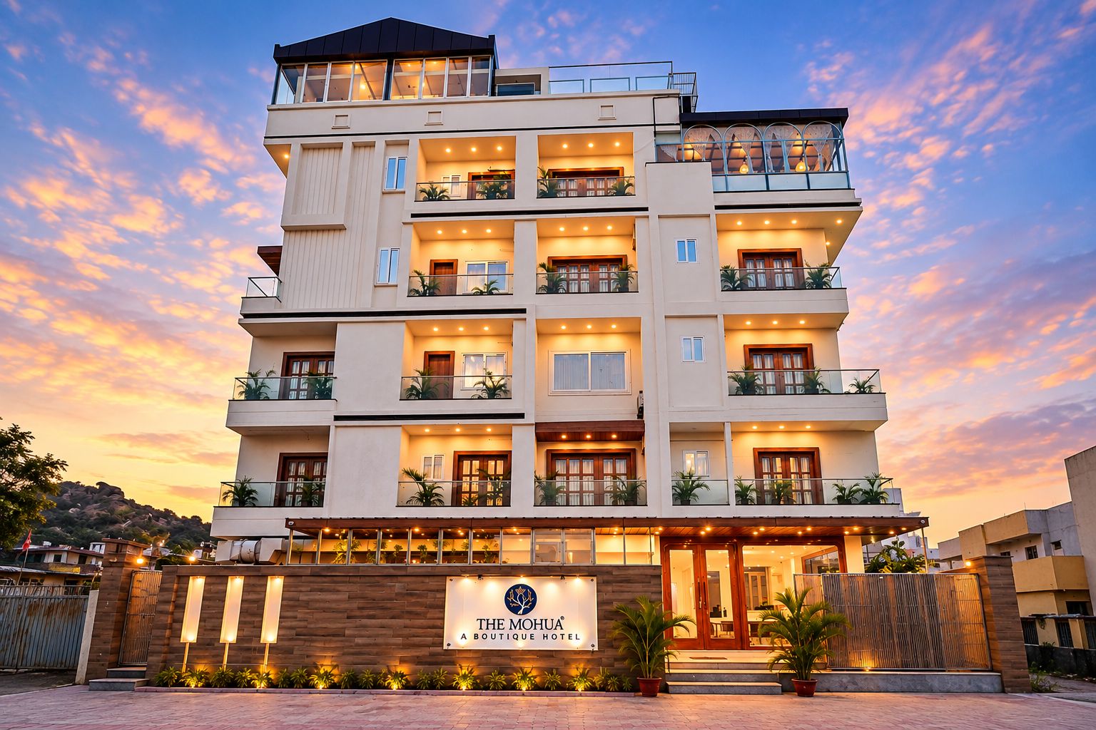 Un hotel de varios pisos con balcones, un cartel que indica que es un hotel boutique y una entrada bien iluminada.