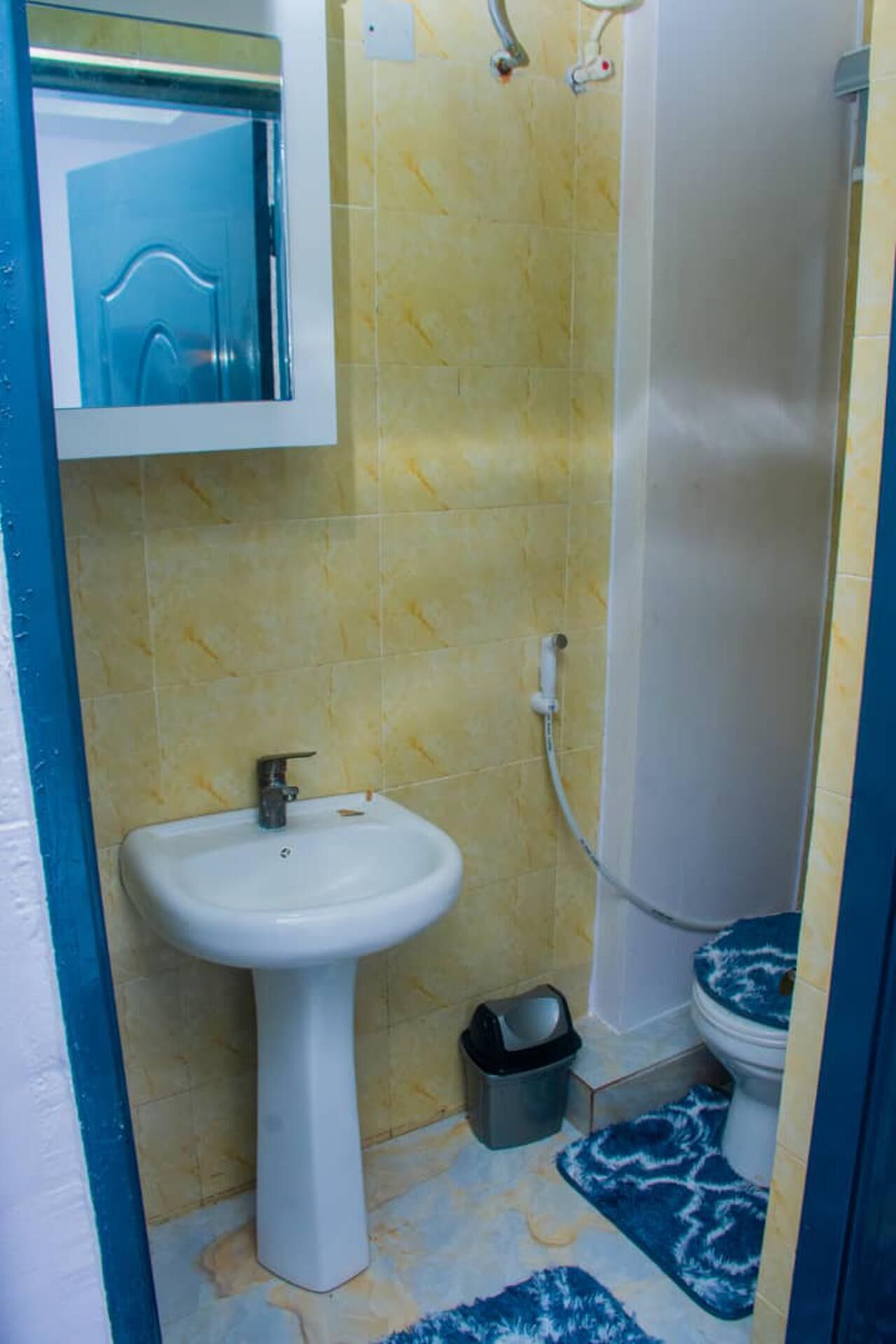 Un baño con un lavamanos blanco, un inodoro y una ducha.
