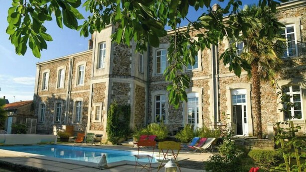 A stone building with a swimming pool, outdoor seating, and a garden. - La Maison D'olivier Avec Piscine Privatif (Mesnard-la-Barotière)