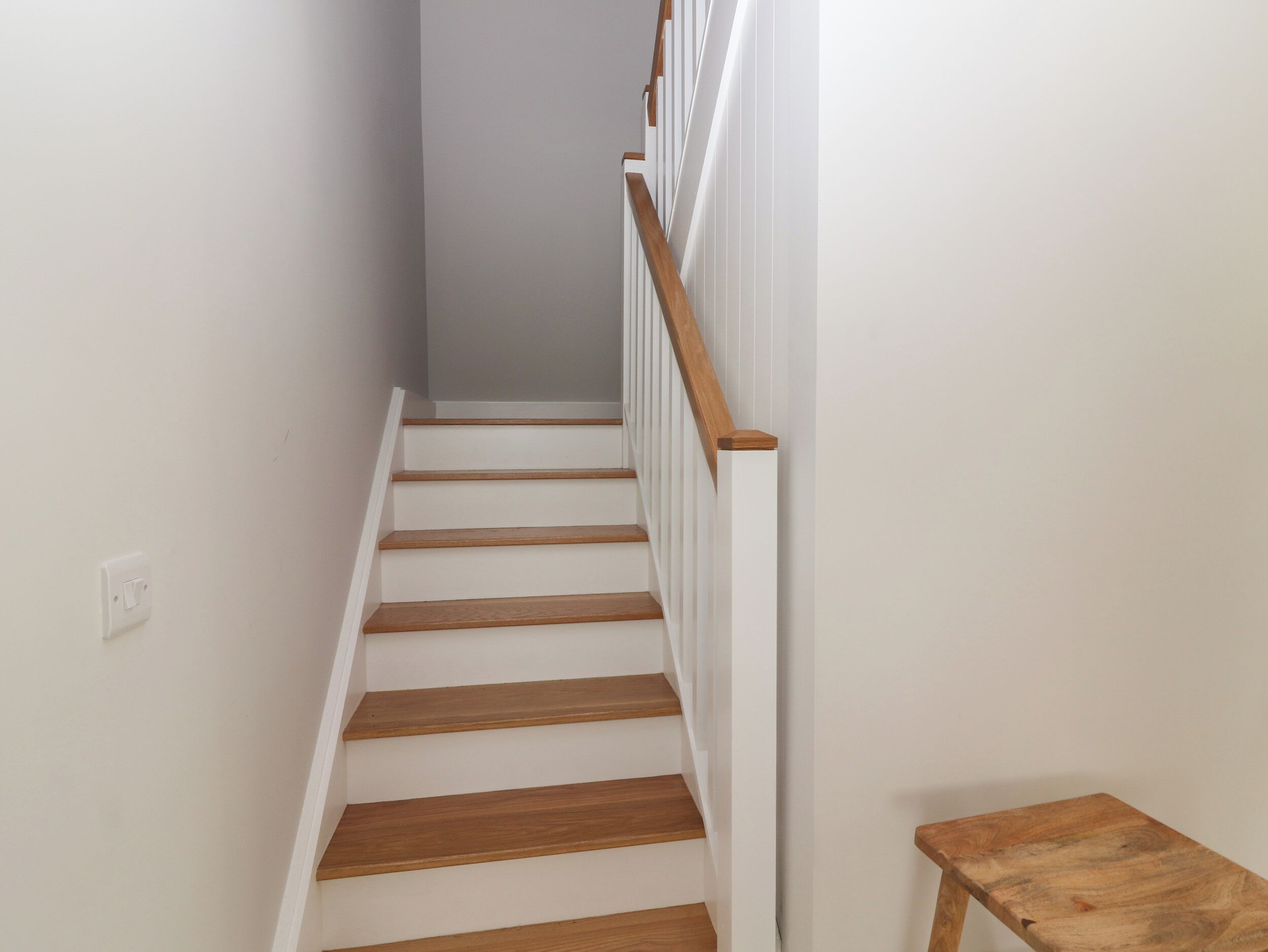 A staircase with wooden steps and white railings.