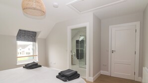 Une chambre avec un lit, une fenêtre, une porte et un espace douche.