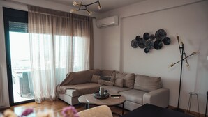 A modern living room with a sectional sofa, a round coffee table, and a decorative wall piece.