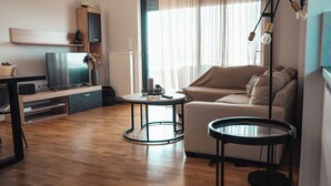 A modern living room with a sofa, a coffee table, and a TV on a stand.
