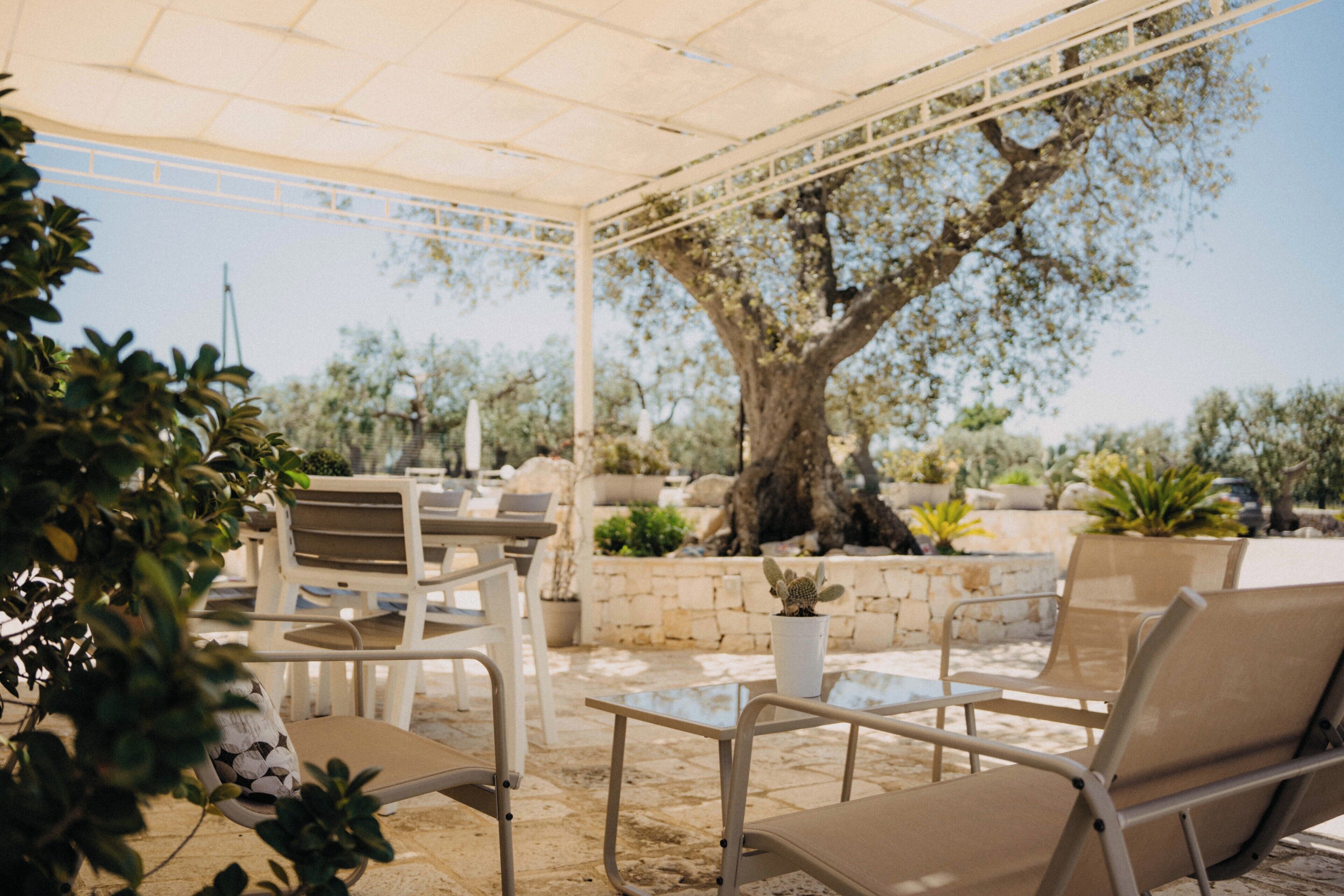 Een terras met zitplaatsen en een pergola.