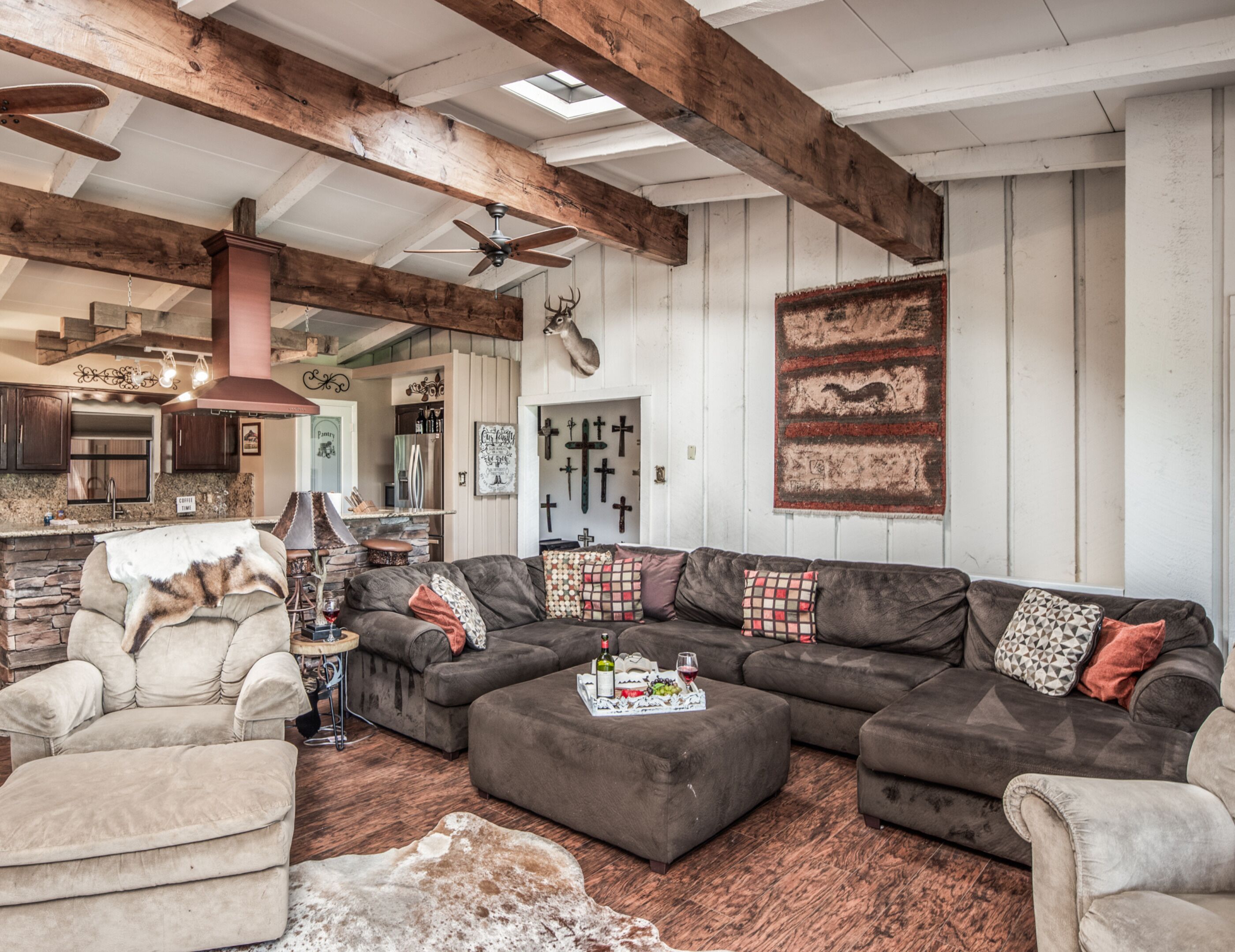 A spacious living room with a sectional sofa, a fireplace, and a stone accent wall.