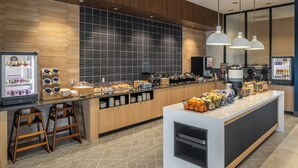 A modern kitchen area with a central island, bar stools, and a refrigerator with a built-in ice maker. - Springhill Suites BY Marriott Canfield (Canfield)