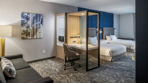A hotel room with a desk, two beds, a sofa, and a large abstract painting on the wall. - Springhill Suites BY Marriott Canfield (Canfield)