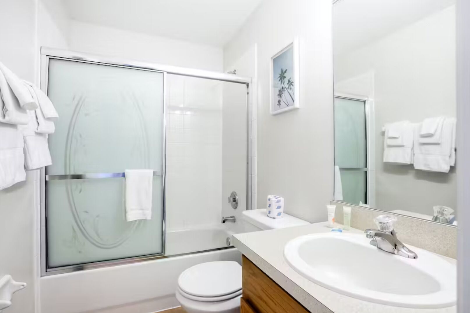 A modern bathroom with a glass shower enclosure, a white sink, and a toilet.