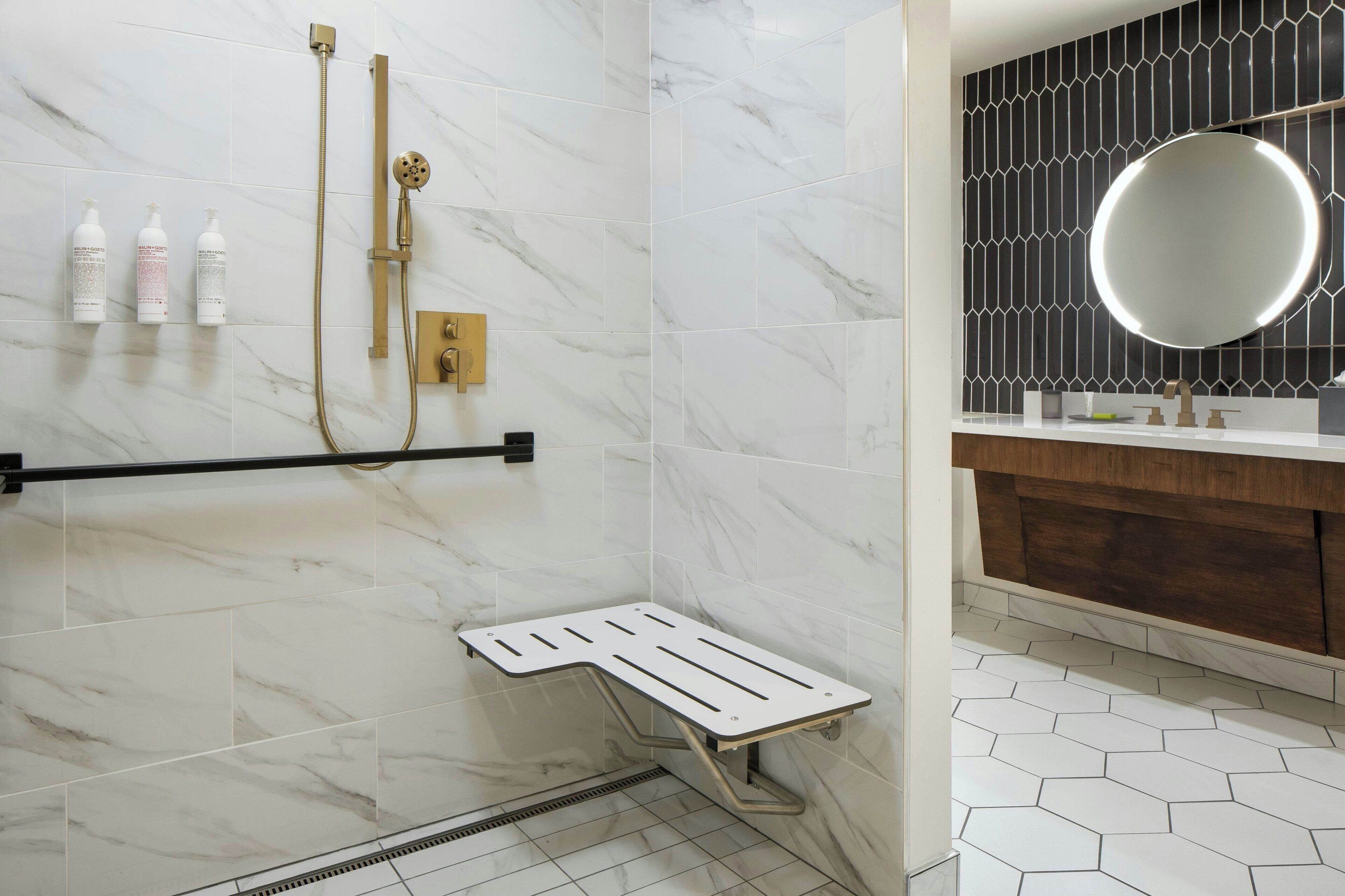 Une salle de bain avec une douche, un meuble-lavabo avec un miroir et des toilettes.