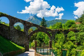 A stone bridge with three arches, lush greenery, and a mountain in the background. - Family Friendly Rosa House Amazing View (Barga)