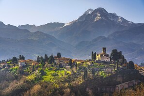 A mountainous village with traditional buildings, a prominent church, and terraced fields. - Family Friendly Rosa House Amazing View (Barga)