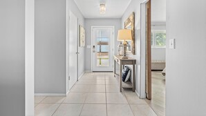 A hallway with a door, a lamp, and a view into a room with a bed. - Tropical Escape–Private Pool Home Near the Sand Hy Tee on Longboat Key by RVA (Longboat Key)