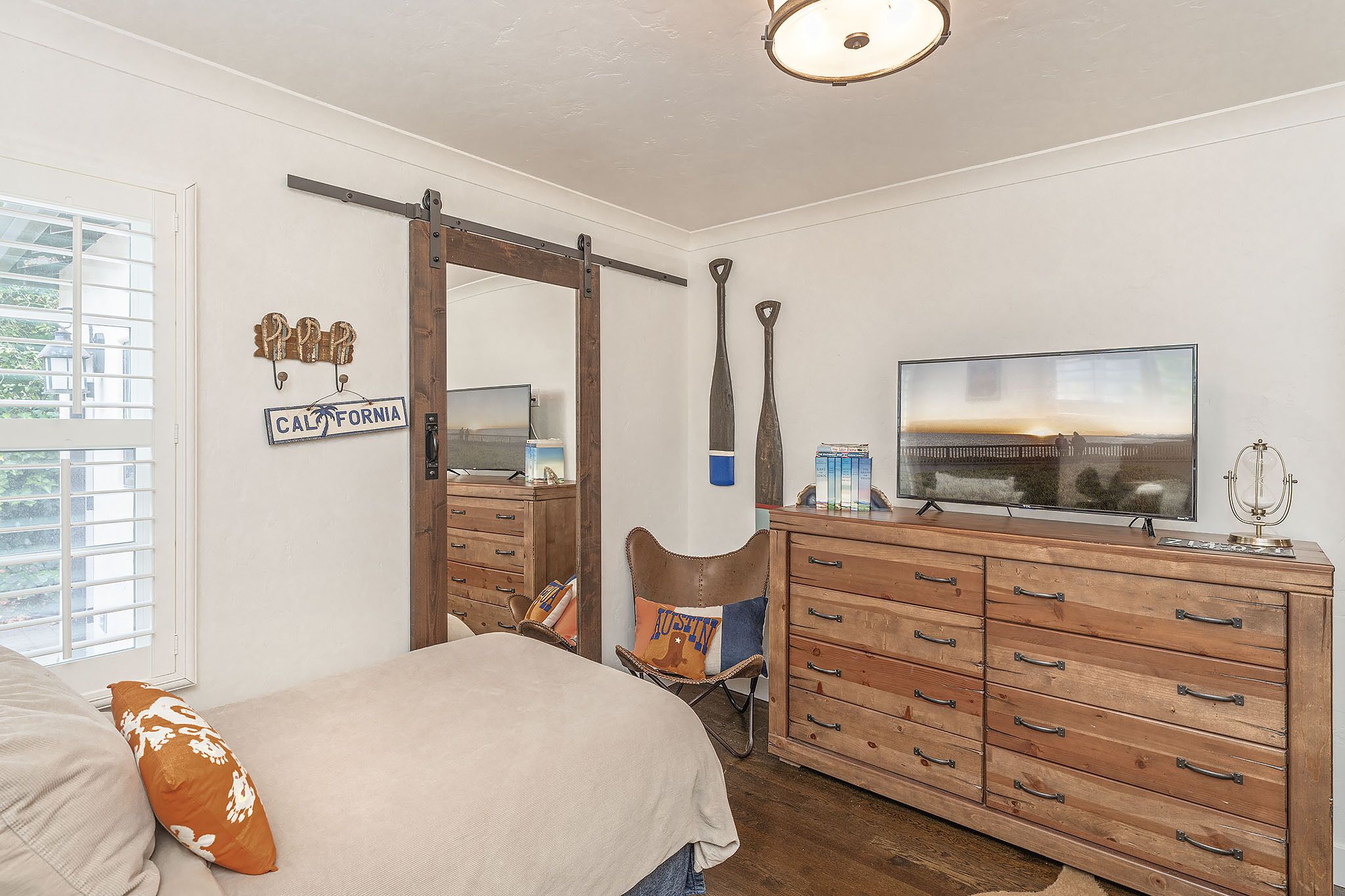 Een slaapkamer met een bed, een kaptafel en een televisie.