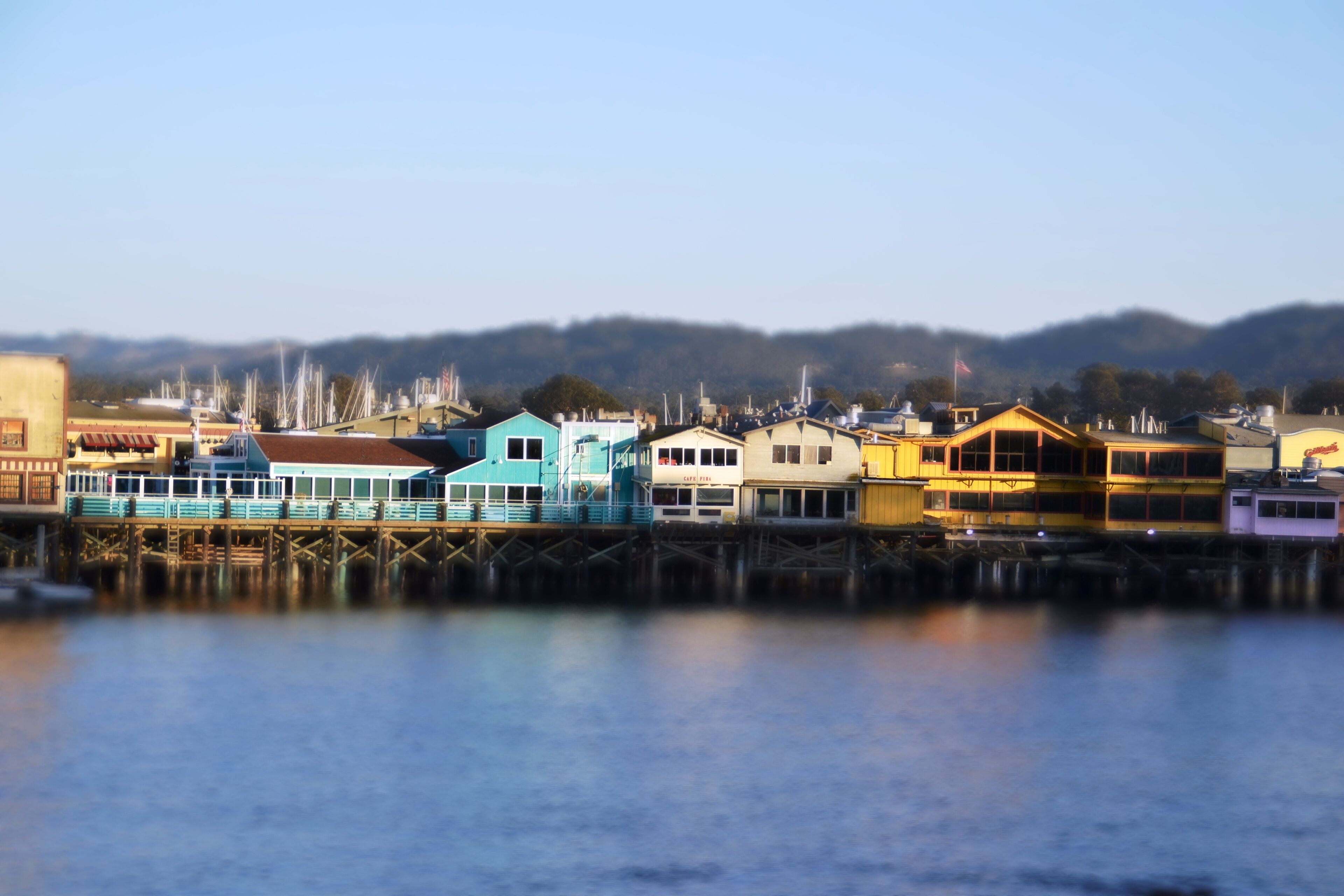 A waterfront property with a dock extending into the water, featuring a row of colorful buildings with a mix of architectural styles.