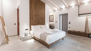 Un dormitorio moderno con estructura de cama de madera, una mesita de noche con un teléfono y un perchero.