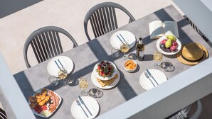 Una mesa dispuesta para una comida, con platos, cubiertos, vasos y un libro.
