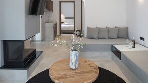 Una sala de estar moderna con una mesa redonda de madera, un tapete negro y una lámpara en el techo.