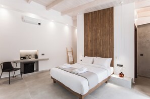 Un dormitorio moderno con una cama grande, una mesita de noche, una silla y una pared de acento de madera.