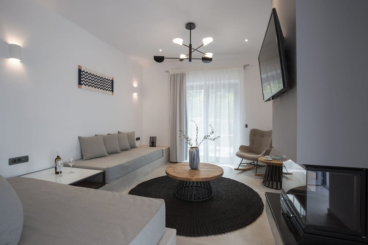 A modern living room with a sofa, coffee table, and a fireplace.