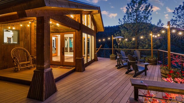 Une terrasse en bois avec des sièges d’extérieur et des guirlandes lumineuses.