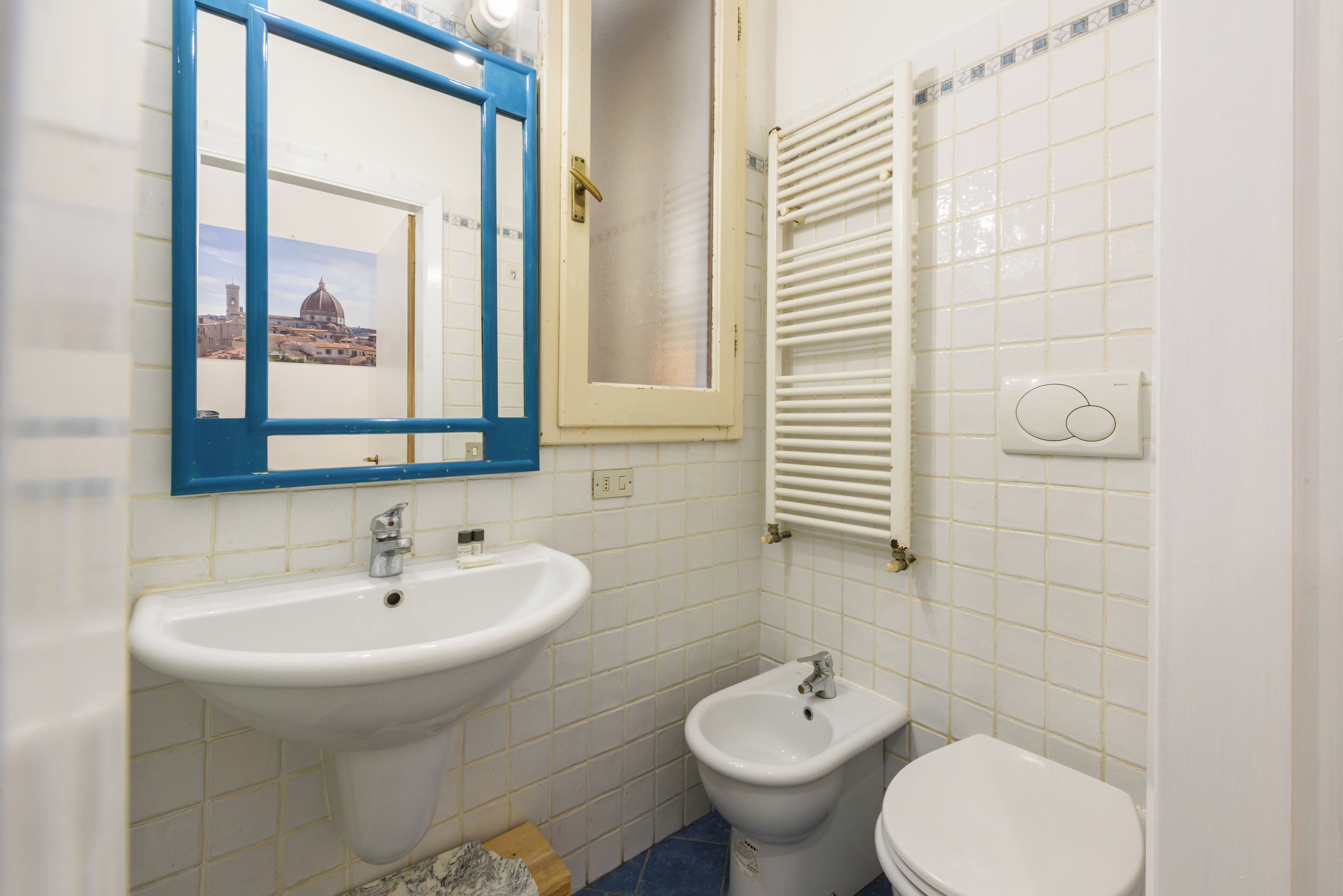 A bathroom with a white sink, a bidet, and a toilet.