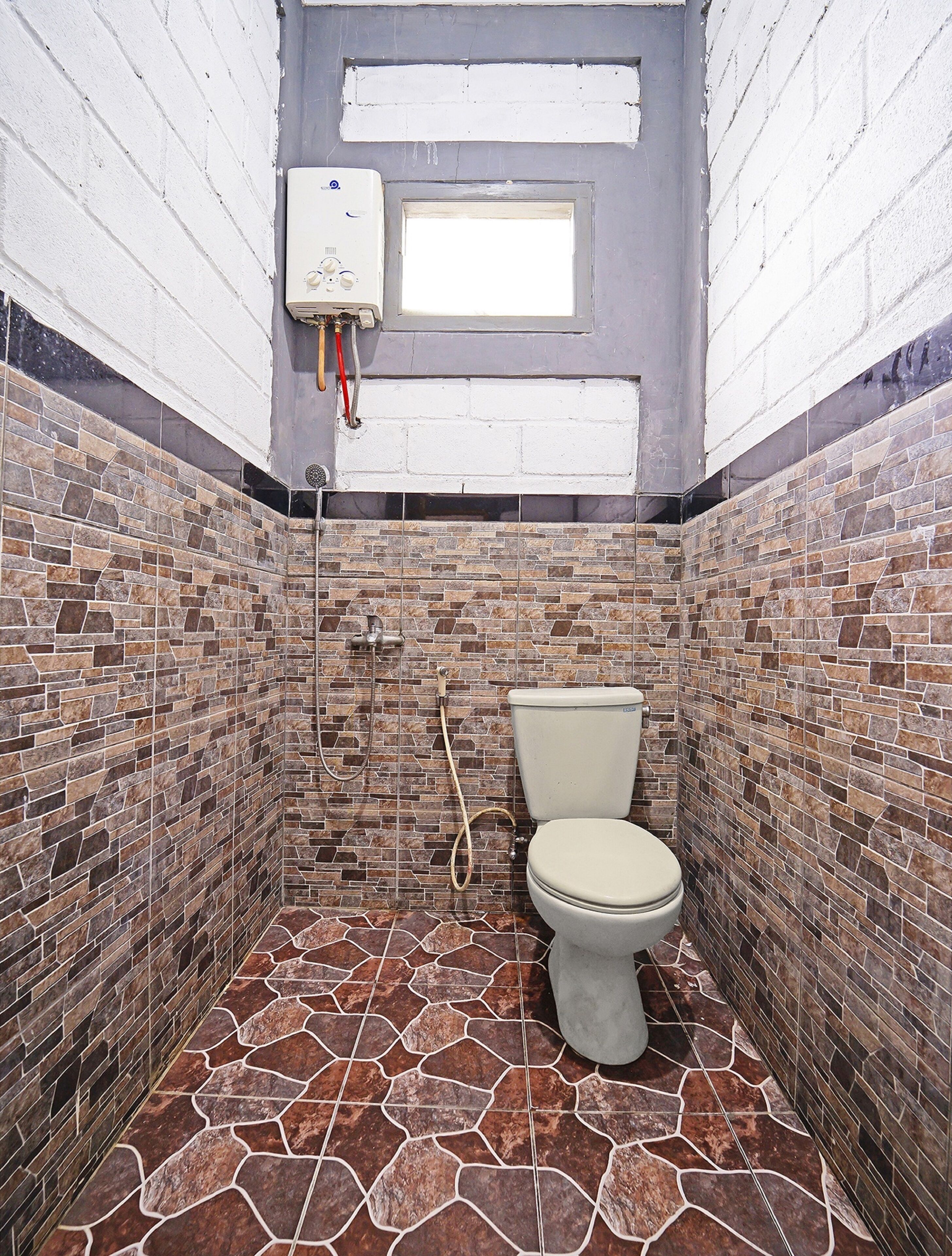 A bathroom with a toilet, shower, and tiled walls.