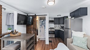 A compact kitchen with a refrigerator, microwave, and oven.