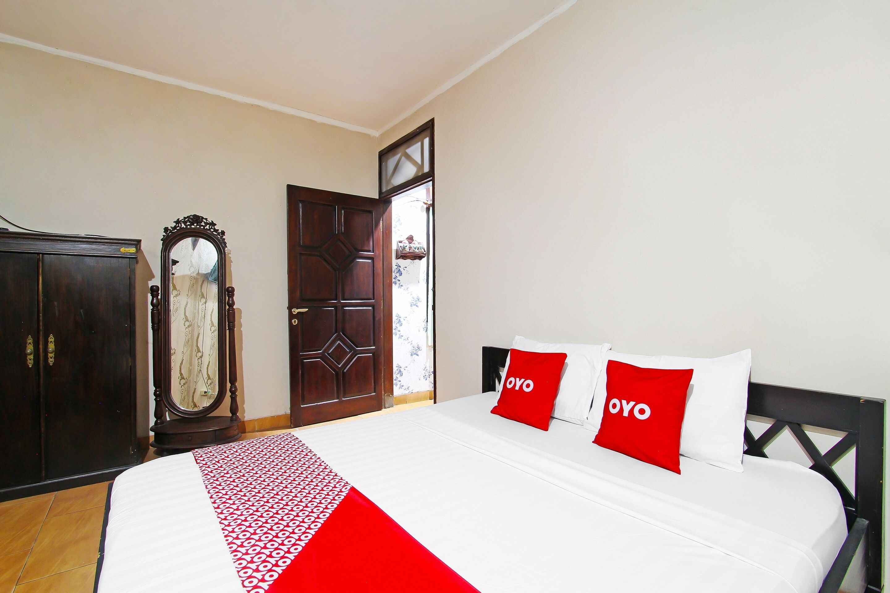 A hotel room with a bed, a wardrobe, and a door.