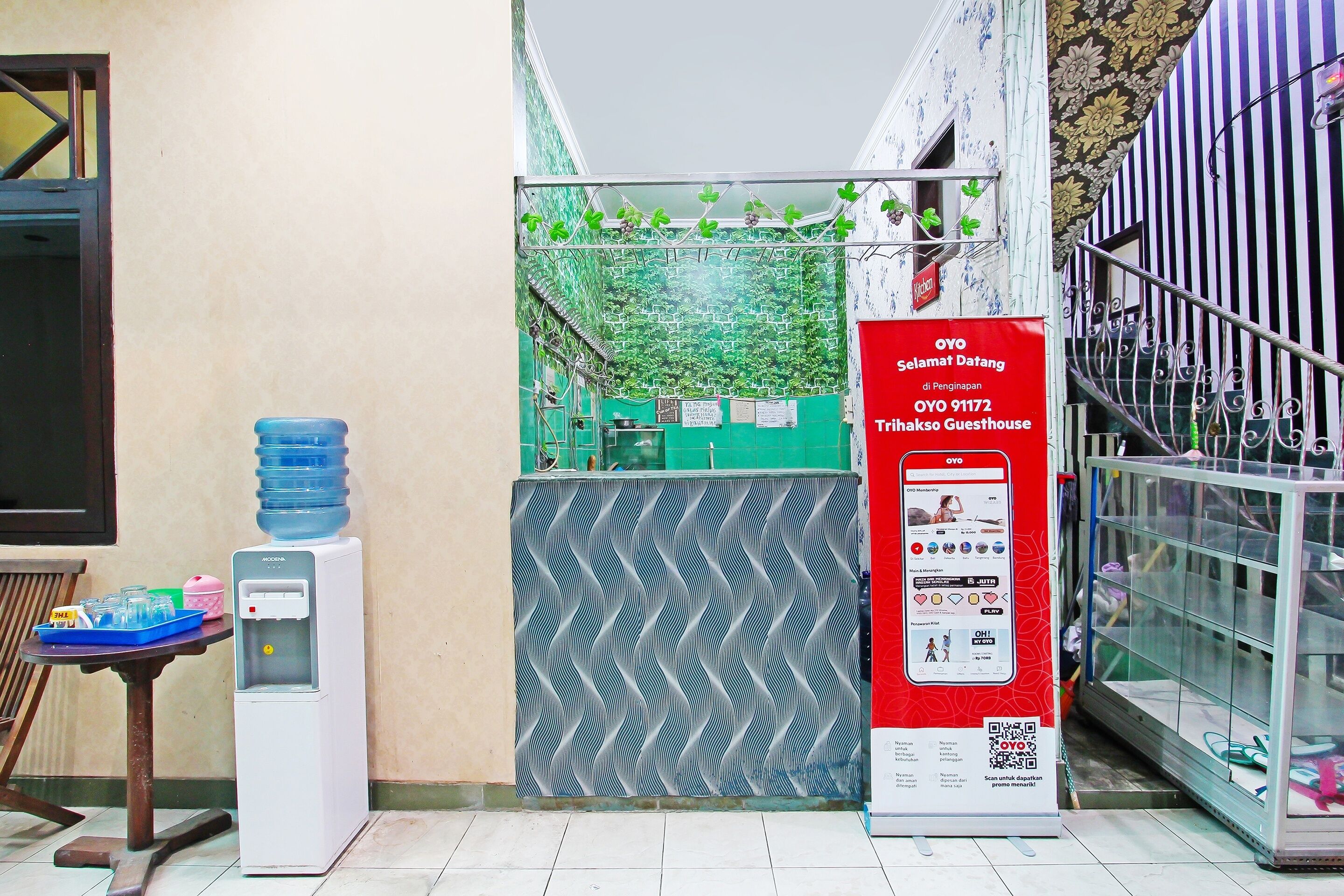 A water dispenser, a table with items, and a red sign with QR code.