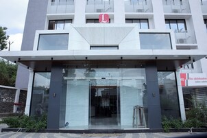 A modern building with a prominent logo, large glass entrance, and a stone facade.
