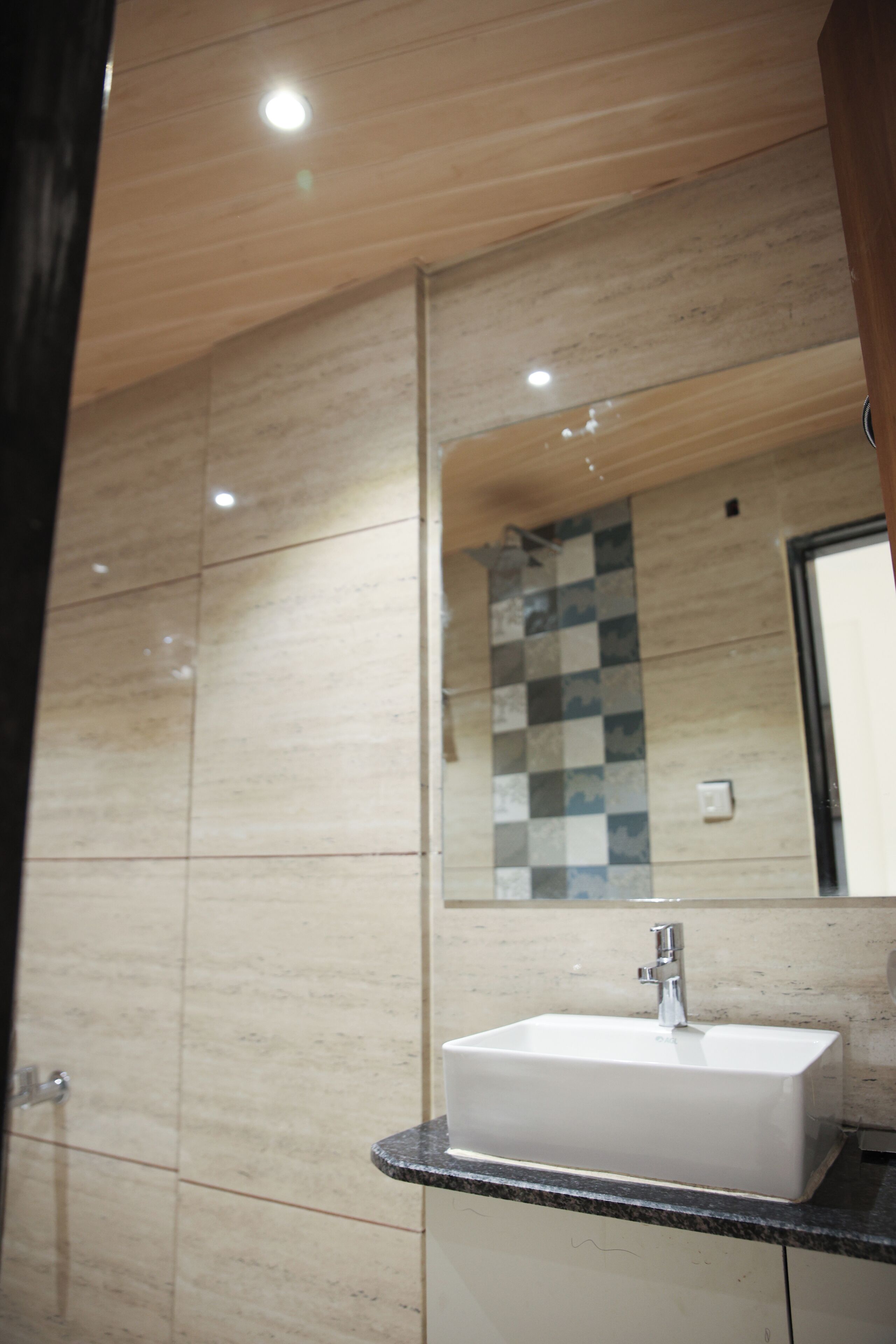A bathroom with a white sink, a mirror, and a tiled wall.