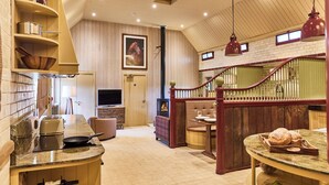 A kitchen with a wooden counter, a television, and a dining area with a table and chairs.