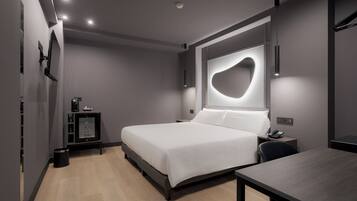 Un dormitorio moderno con cama, mesita de noche y escritorio.