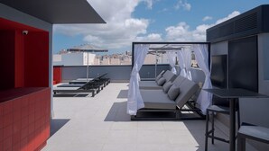 A rooftop terrace with a seating area, a table, and a canopy structure. - Hotel LIVVO La Escarlata (Las Palmas de Gran Canaria)