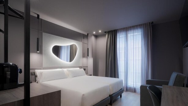 A modern hotel room with a large bed, a desk, and a chair. - Hotel LIVVO La Escarlata (Las Palmas de Gran Canaria)