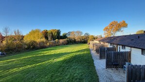 Una hilera de casas de madera con un sendero pavimentado y un área verde.