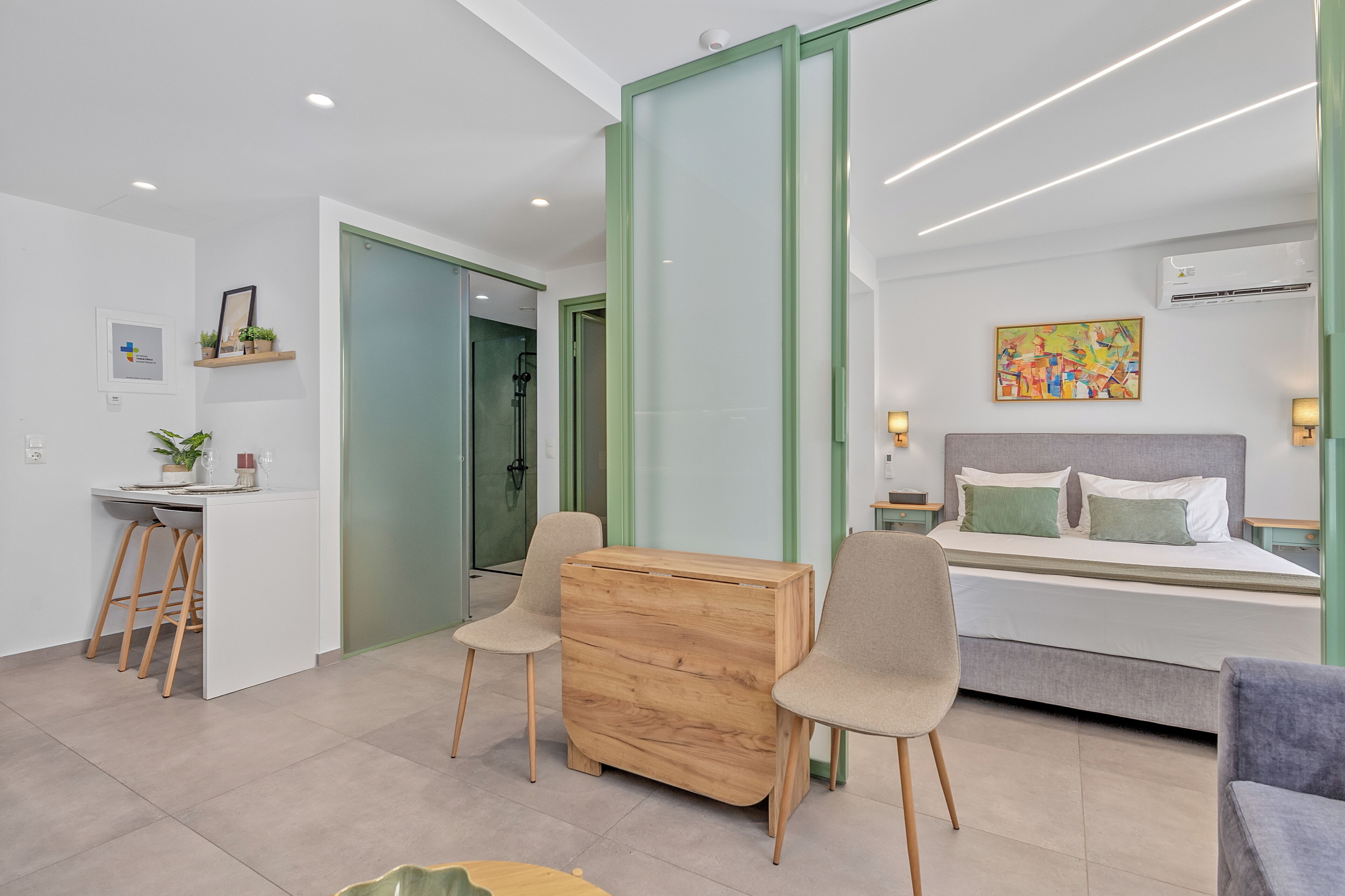 A modern bedroom with a bed, bedside tables, a desk, and chairs.