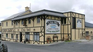A traditional building with a sign reading "CRA BUI" and "HOLMES of DOOHOMA."