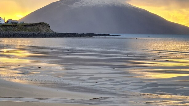 A beach with a mountain in the background.