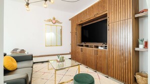 A living room with a sofa, a coffee table, a television, and a wooden cabinet. - Art Deco 2BR in Polanco  Steps to Parque Lincoln (Ciudad de México)