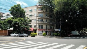 A multi-story building with a ground-floor commercial space, a pedestrian crossing, and parked cars. - Art Deco 2BR in Polanco  Steps to Parque Lincoln (Ciudad de México)